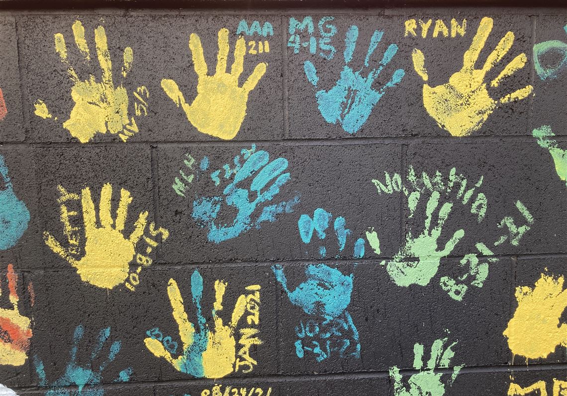 Some of the handprints of people recovering from drug addiction are seen on Dec. 9, 2021, on a wall in the parking lot of Provoking Hope, an addiction recovery center in McMinnville, Ore. Along with the handprints are the dates when they became 